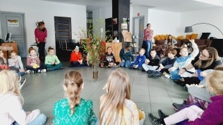 dzieci siedzą na podłodze w kółku