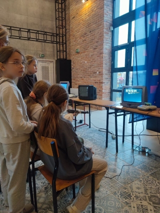 uczniowie 5a oglądają sprzęt komputerowy z lat 80-tych