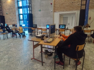 uczniowie 5a oglądają sprzęt komputerowy z lat 80-tych