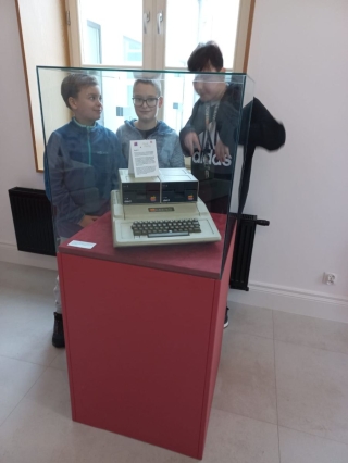 uczniowie 5b oglądają sprzęt komputerowy z lat 80-tych