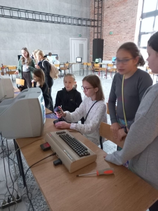 uczniowie 5b oglądają sprzęt komputerowy z lat 80-tych