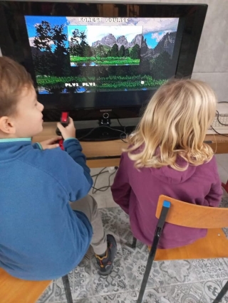 uczniowie 5b oglądają sprzęt komputerowy z lat 80-tych