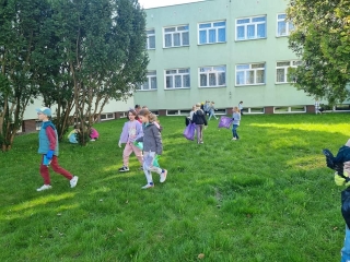 Uczniowie klas 1 podczas sprzątania terenów w pobliżu szkoły