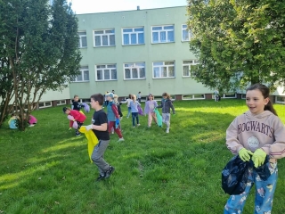 Uczniowie klas 1 podczas sprzątania terenów w pobliżu szkoły
