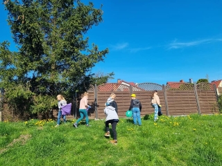 Uczniowie klas 1 podczas sprzątania terenów w pobliżu szkoły