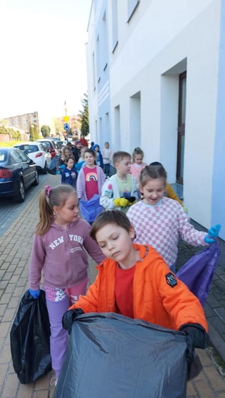 Uczniowie klas 1 podczas sprzątania terenów w pobliżu szkoły