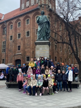 uczniowie przy pomniku Kopernika w Toruniu