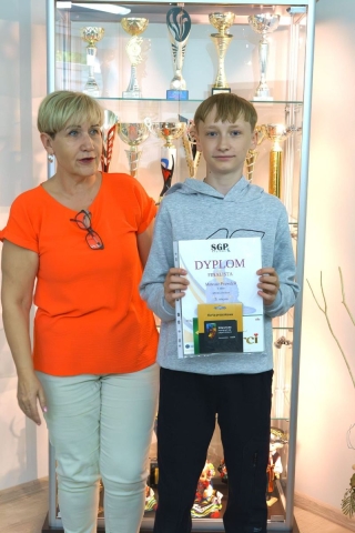 nagrodzony uczeń z nauczycielem