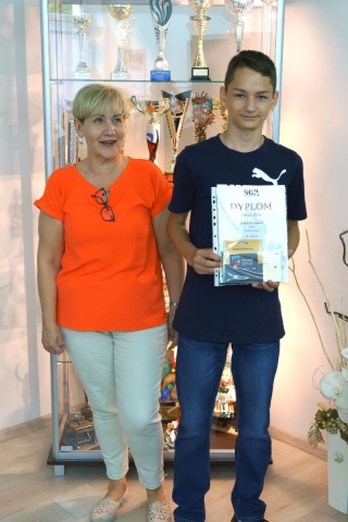 nagrodzony uczeń z nauczycielem