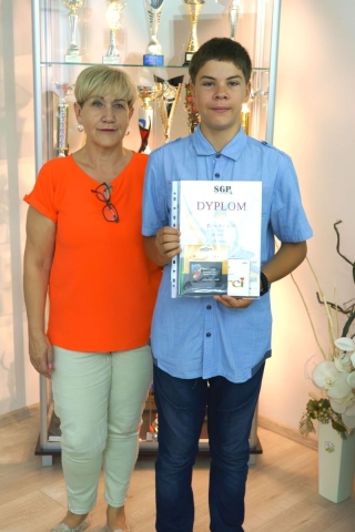 nagrodzony uczeń z nauczycielem