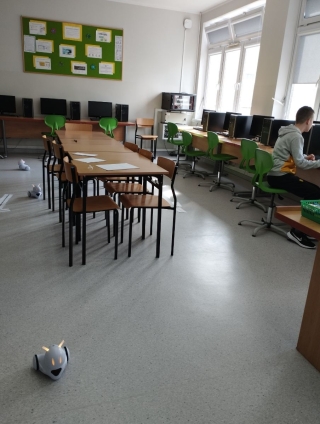 uczniowie na kole informatycznym uczą się programowania roboty