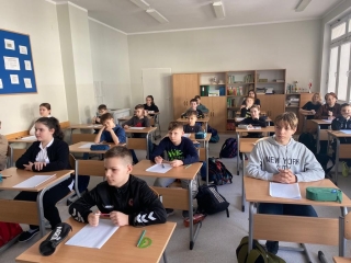 uczniowie siedzący na sali - rozwiązują zadania