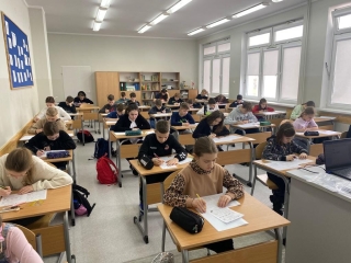 uczniowie siedzący na sali - rozwiązują zadania