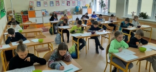 uczniowie siedzący na sali - rozwiązują zadania